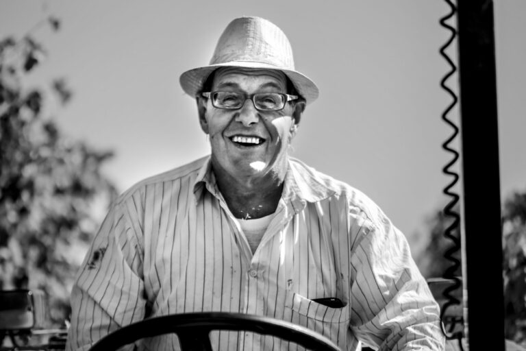 il viso sorridente dopo la vendemmia di un collaboratore del team di fattoria di montechiari sul trattore che porta i grappoli appena vendemmiati